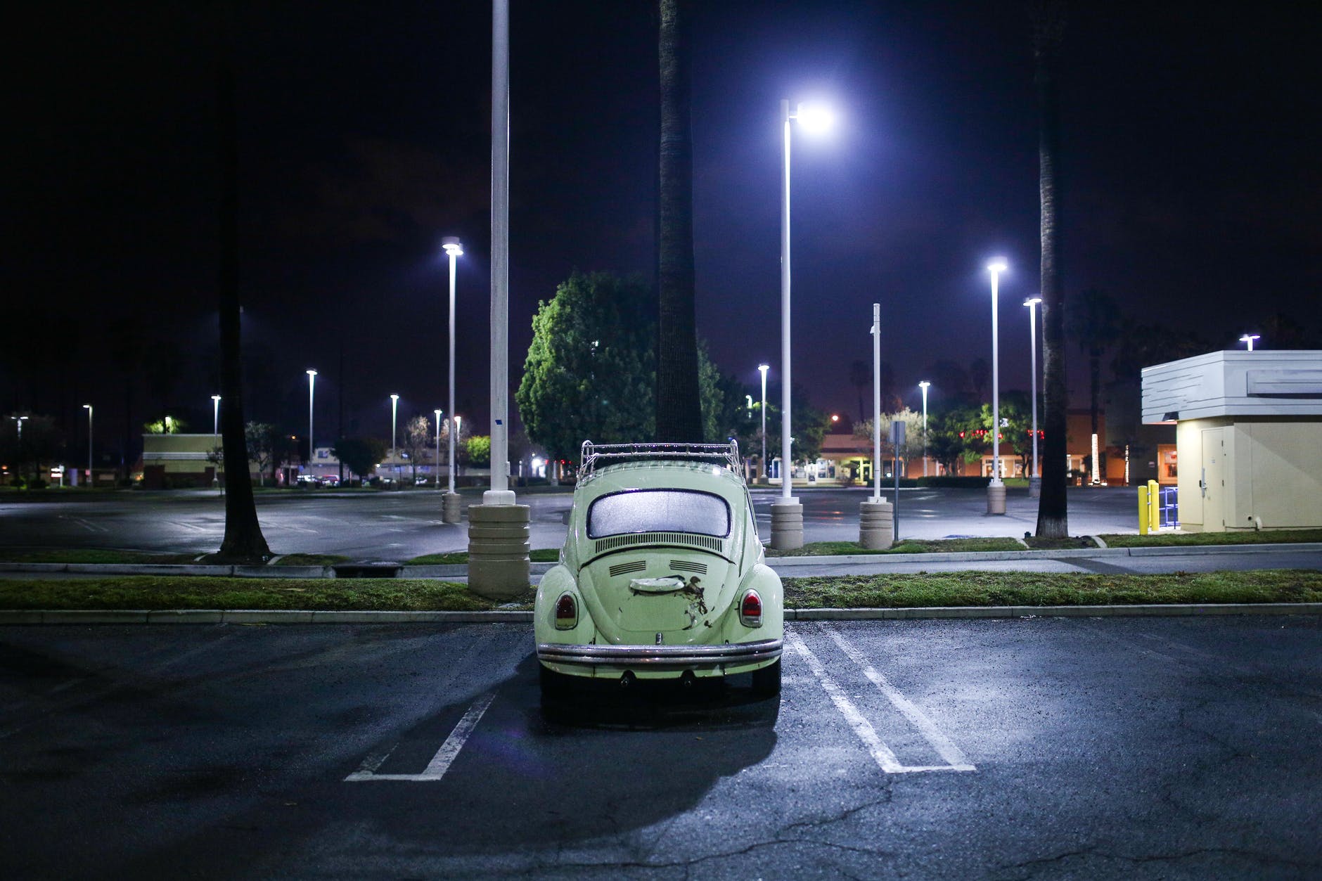 vintage car parked in empty parking lot at night